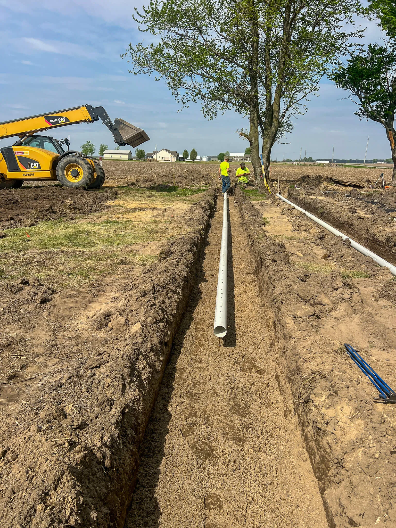 Advanced Drainage crew laying drain tile pipe in a Cass County farm field