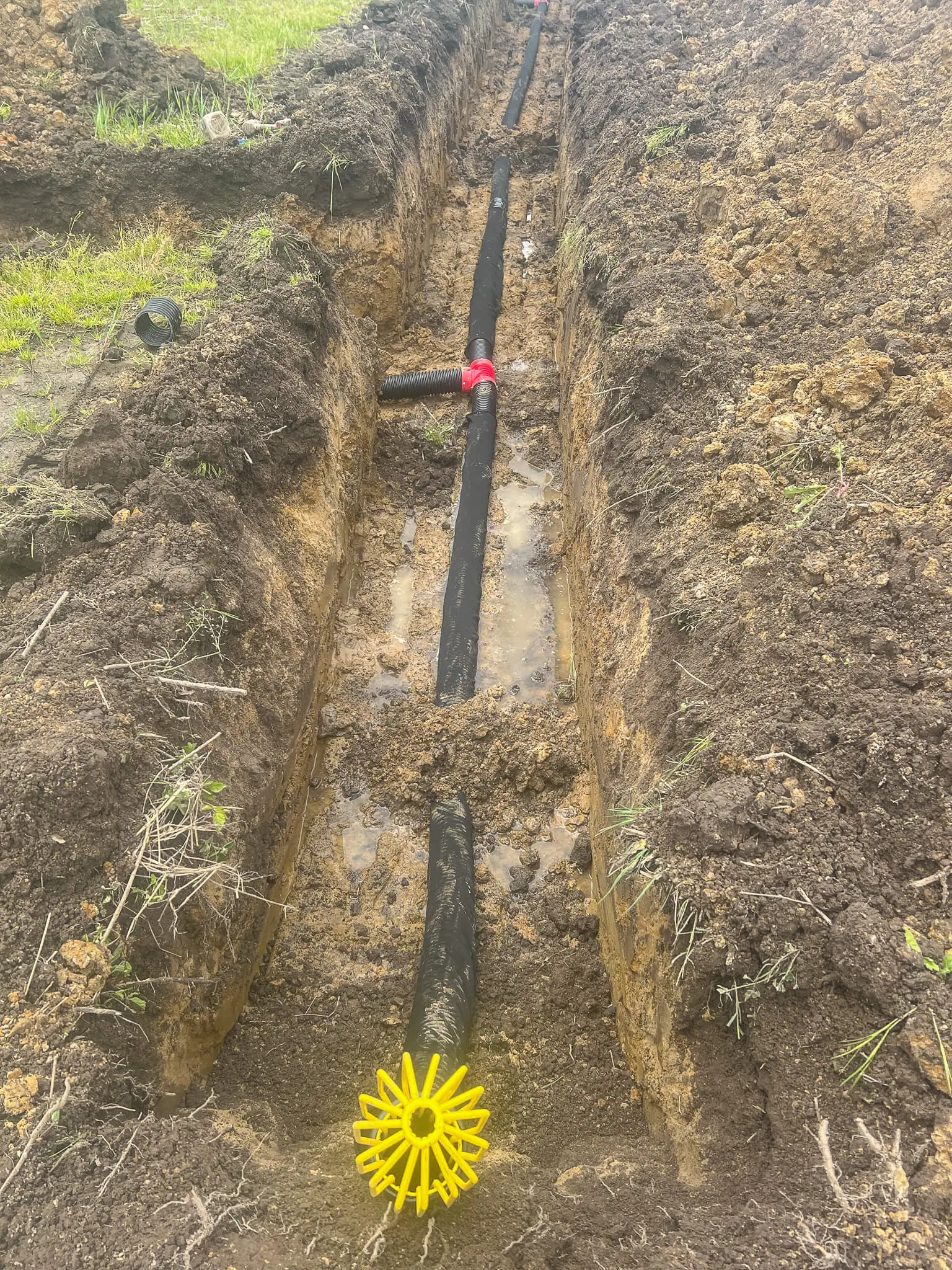 Rock-lined drainage swale beside a new pole barn